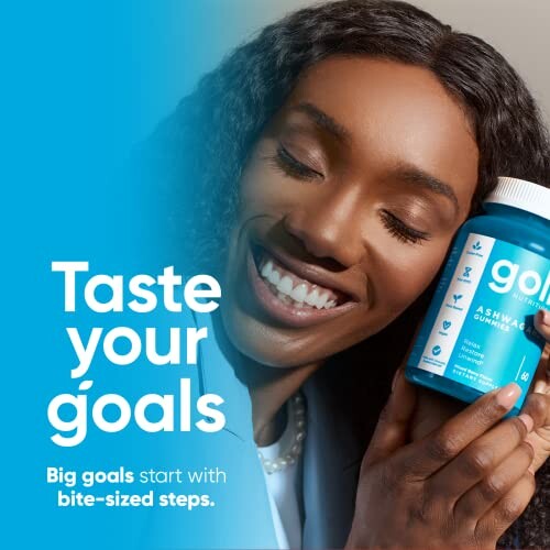 Woman smiling and holding a bottle of Goal Ashwagandha Gummies.